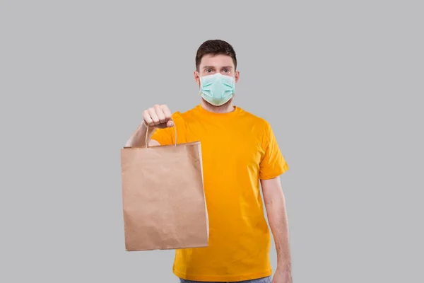 Homem Entrega Vestindo Máscara Médica Rapaz Entrega Camiseta Amarela Isolados — Fotografia de Stock