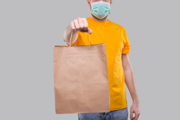 Teslimatçı Tıbbi Maske Takıyor Sarı Tişört Teslimatçısı Yemek Teslimatı Eve — Stok fotoğraf