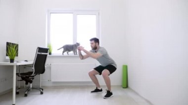 Evde Çömelme Yapan Adam. Adam evde çalışıyor. Home Sport, Sağlıklı Yaşam, Karantina Konsepti. Evde Spor