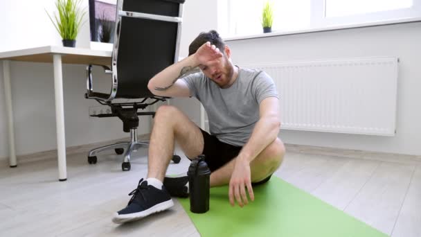 Hombre cansado después del entrenamiento en casa. El hombre bebiendo agua después de los deportes. Inicio Deporte, Vida Saludable, Concepto de Cuarentena . — Vídeo de stock