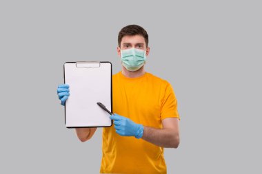 Tıbbi Maske Giyen Adam ve Eldivenleri Kalem Panosu ile Gösteriyor. Ellerindeki boş pano. İzole edilmiş
