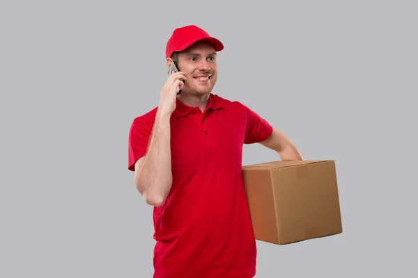送货员拿着盒子在电话里交谈 快递员与客户交谈 男人用电话 被隔离了 — 图库照片