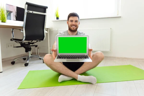 Man Showing Laptop with Green Screen. Man Smilling after Home Sports. Home Sport, Healthy Life, Quarantine Concept. Man Sitting. Workout