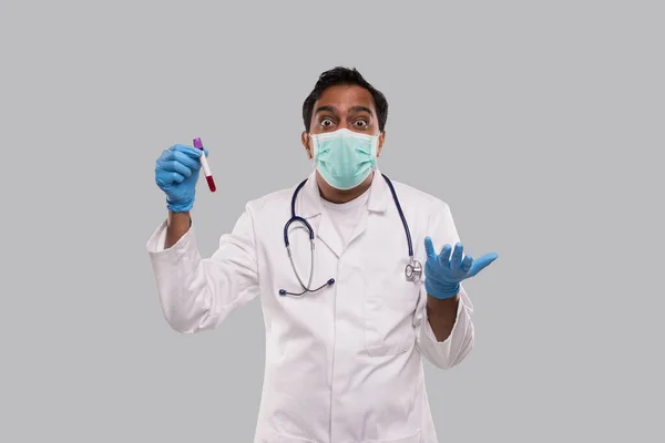 Dokter verrast Holding bloed buis analyse dragen van medische maskers en handschoenen. Indian Man Doctor Science, Medisch Concept. geïsoleerd. — Stockfoto