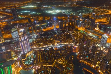 Dubai şehir merkezinde şehir ışıklarıyla dolu bir gece sahnesi.