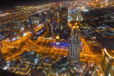 Dubai şehir merkezinde şehir ışıklarıyla dolu bir gece sahnesi.