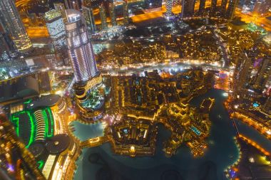 Dubai şehir merkezinde şehir ışıklarıyla dolu bir gece sahnesi.