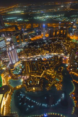 Dubai şehir merkezinde şehir ışıklarıyla dolu bir gece sahnesi.