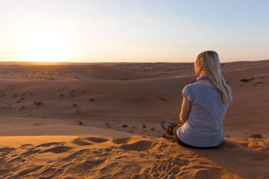 Sarışın kız Wahiba Sands, Umman gün batımında rahatlatır