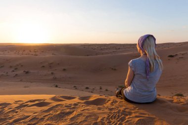 Sarışın kız Wahiba Sands, Umman gün batımında rahatlatır