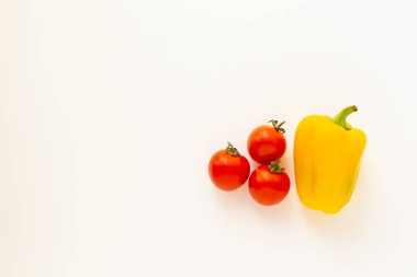 Beyaz arka planda üç kiraz domatesli taze organik sarı dolma biber.