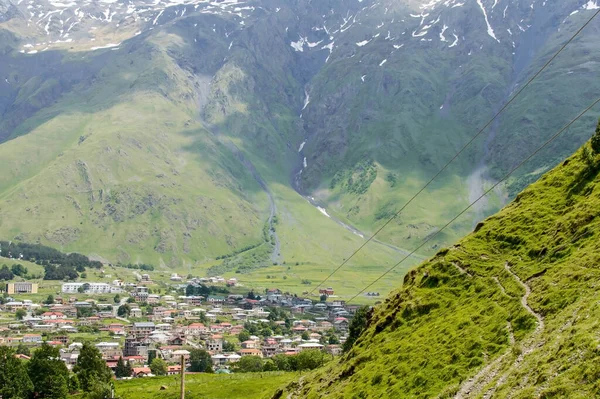 Een Klein Stadje Een Bergkloof Tussen Groene Bergen Met Besneeuwde — Stockfoto