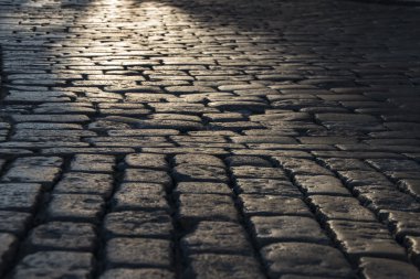 Siyah Arnavut kaldırımlı yolda gördüm ışık yansıması ile taş yol arka plan. Siyah veya koyu gri taş döşeme doku.