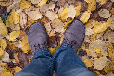 Adam sonbahar yaprakları üzerinde Çizmeli metrelik