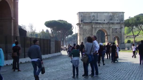 ROMA, ITALIA - 25 de marzo de 2017: Gente caminando en Roma, en el fondo del Arco de Constantino en el Coliseo . — Vídeos de Stock