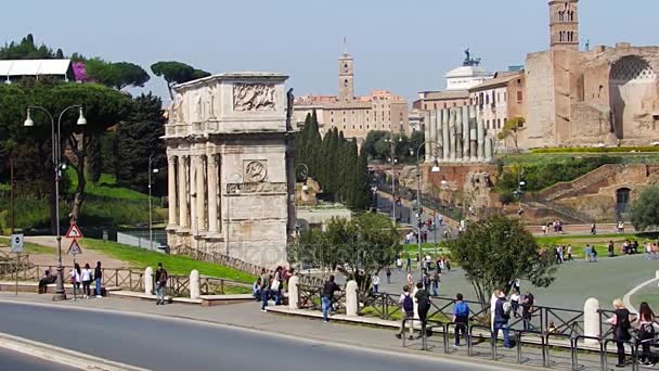 Rome, Italië - 25 maart, 2017: Mensen lopen in Rome, in de achtergrond van de boog van Constantijn in het Colosseum. — Stockvideo