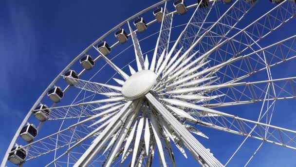 Roda gigante girando no fundo do céu azul . — Vídeo de Stock