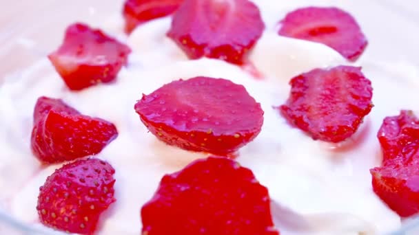 Pieces of strawberries in cream, rotating. Macro shot. — Stock Video