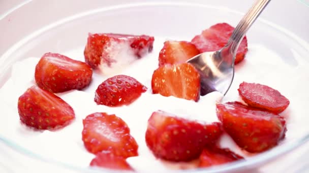 Bitar av jordgubb tas från cream av sked. Makro skott. tidsfördröjning. — Stockvideo