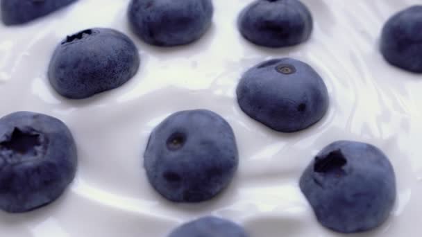 Closeup Blueberries in natural yogurt rotating. Seamless looping, 4k. Fruit background. — Stock Video