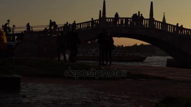 Venedik sokaklarında yürüyüş turistler. Venedik akşamları. Köprünün büyük Kanal üzerinde yürüyen turist. Romantik Venedik, İtalya.
