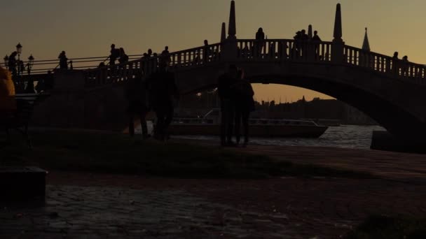 Turister gå på gatorna i Venedig. Kväll i Venedig. Turister promenader längs bron över Grand Canal. Romantik i Venedig, Italien. — Stockvideo