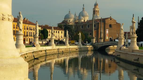 Padova, Olaszország - október, 2017: Piazza Prato della Valle Santa Giustina apátság a. Prato della Valle elliptikus square, körülvéve egy kis csatorna és szobrok gyűrű által határolt. — Stock videók