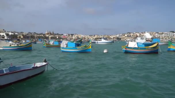 Marsachlokk - Мальта, квітень, 2018: Барвисті Мальтійська човни в гавань на Мальті в рибальські села Marsachlokk. — стокове відео