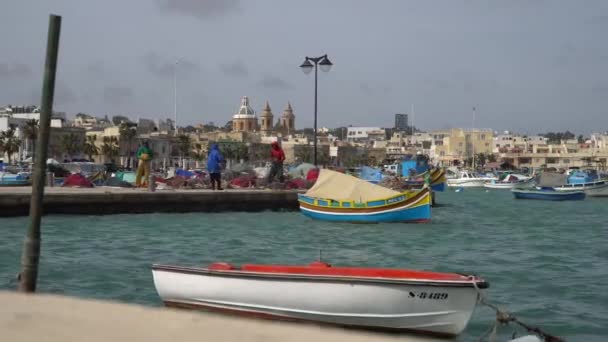Marsachlokk - Malta, kwietnia, 2018: Kolorowe maltańskie łodzie w porcie na Malcie w fishing village Marsachlokk. — Wideo stockowe