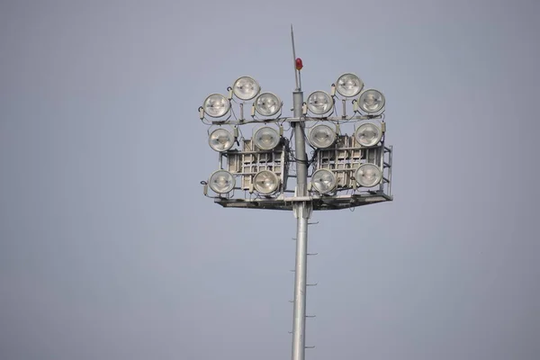 Cricket stadium floodlights at day with blue sky, High power spotlights, grandstand and outdoor Cricket pitches in the evening in Delhi India