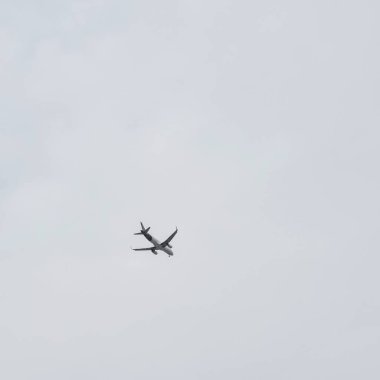 Delhi 'deki Kutub Minar yakınlarında, bulutlu gökyüzünde uçan uçak, gökyüzünde yüksek uçan uçak...