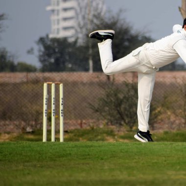 Güneşli bir günde sahada oynayan kriket oyuncusu, sahada oynayan kriket oyuncusu, sahada kriket oynayan oyuncular.