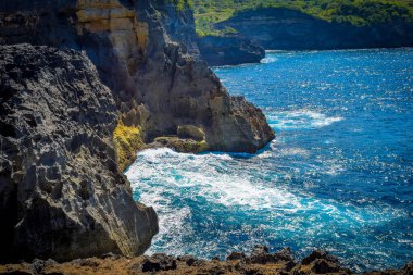 Güzel Meleğin Billabong Manzarası. Melek 'in Nusa Penida' daki Billabong 'unun girişinde keskin dramatik kayalar ve çarpıcı dalgalar, muhteşem Melekler Billabong Nusa Penida, Bali Endonezya' da, Angel 's Billabong adada doğal sonsuzluk havuzu