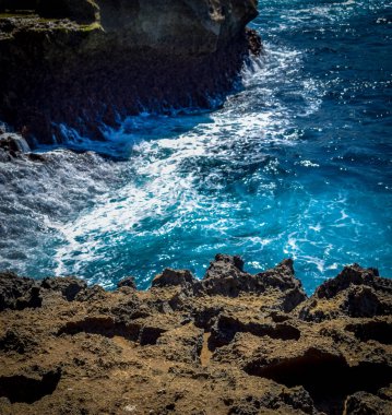 Güzel Meleğin Billabong Manzarası. Melek 'in Nusa Penida' daki Billabong 'unun girişinde keskin dramatik kayalar ve çarpıcı dalgalar, muhteşem Melekler Billabong Nusa Penida, Bali Endonezya' da, Angel 's Billabong adada doğal sonsuzluk havuzu