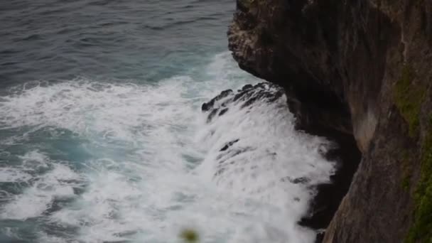 Vue des vagues géantes, de la mousse et des éclaboussures dans l'océan près de la falaise d'Ulwatu dans le temple d'Ulwatu à Bali Indonésie