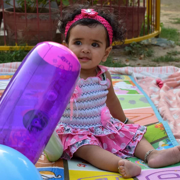 图片中甜美的女婴在花环里 可爱的12个月大的小女孩 蹒跚学步的小女孩 可爱的小女孩的特写 在户外拍照时笑着摆出可爱的姿势 — 图库照片