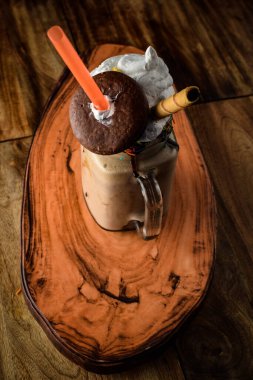 Büyük bir kavanozda dondurmalı kahve, seçici odak, kakaolu cam kavanoz veya sıcak çikolata, saman