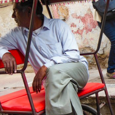 Delhi, Hindistan - 9 Aralık 2019: Chandni Chowk pazarında eski Delhi, Hindistan caddesinde, Rickshaw 'un sokak fotoğrafçılığı sıcağın altında aracı süren bisiklet rickshaw