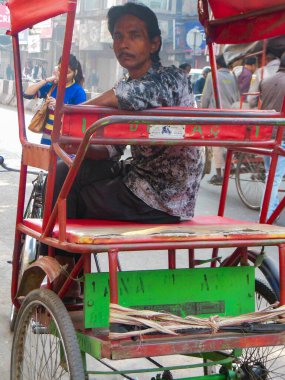 Delhi, Hindistan - 9 Aralık 2019: Chandni Chowk pazarında eski Delhi, Hindistan caddesinde, Rickshaw 'un sokak fotoğrafçılığı sıcağın altında aracı süren bisiklet rickshaw