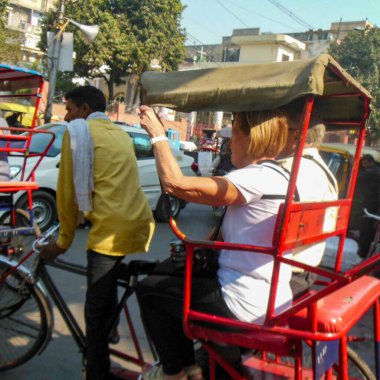 Delhi, Hindistan - 9 Aralık 2019: Chandni Chowk pazarında eski Delhi, Hindistan caddesinde, Rickshaw 'un sokak fotoğrafçılığı sıcağın altında aracı süren bisiklet rickshaw
