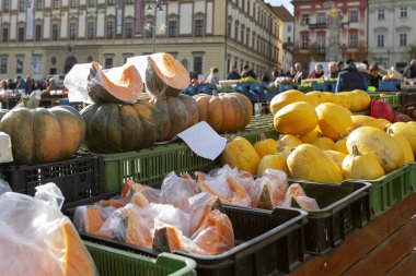Fındık kabağı ve karpuz. Plastik tencerelere sarılmış ve yeşil bir sandığa konmuş balkabağı parçaları. Arka planda sarı karpuzlar.