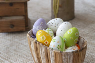 Güzel Paskalya dekorasyonu. Tavuk, paskalya yumurtaları ve güzel çiçeklerle dolu musluk. Işık arkaplanındaki fotoğraf.