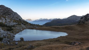 İtalyan Dolomitler, gün batımından sonra Valparola Gölü, göl yüzeyinde gökyüzünün yansıması ve geçmek için manzara