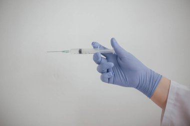 Doktor elinde koronovirüs aşısı olan bir şırınga tutuyor.