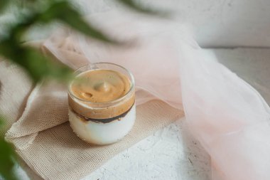 Sütlü buzlu Dalgona kahvesi. Bardakta nefis, soğuk bir içecek. Beyaz arkaplanda bir kopya alanı var.