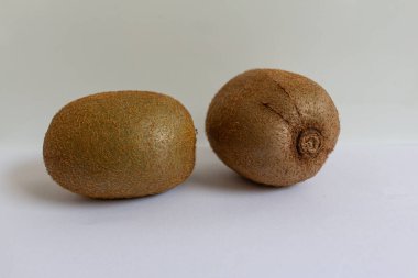 Beyaz arka plan ve üst manzara üzerinde güzel olgun kivi meyveleri.