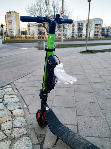 Electric scooter rental in the conditions of coronavirus and self-isolation in Poland with disposable gloves for protection against the virus.