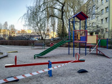 Bialystok / Polonya-08.04.2020: Çocuklar için oyun alanları özel olarak çitle çevrili, kapalı salıncaklar, banklar, kum havuzu insanları yok, Coronavirus 'tan izolasyon nedeniyle boş sokaklar