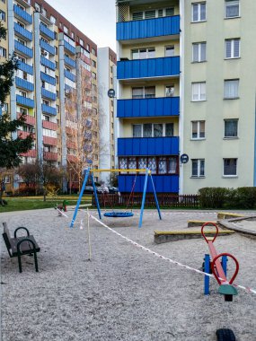 Bialystok / Polonya-08.04.2020: Çocuklar için oyun alanları özel olarak çitle çevrili, kapalı salıncaklar, banklar, kum havuzu insanları yok, Coronavirus 'tan izolasyon nedeniyle boş sokaklar