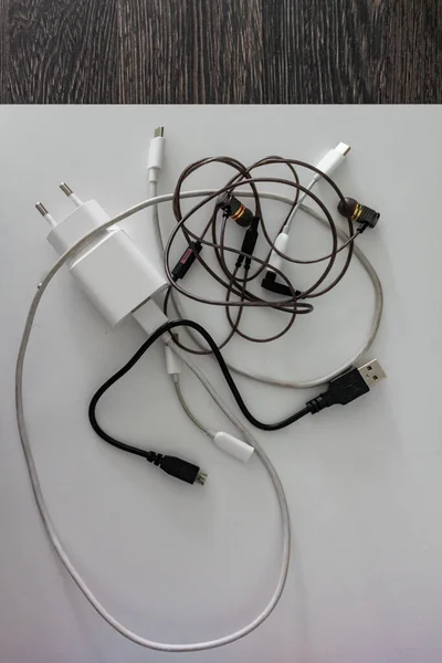 白黒線 電話充電器 ヘッドフォン ケーブル アダプターの塊と長方形 白い背景のアプライアンスとコード — ストック写真